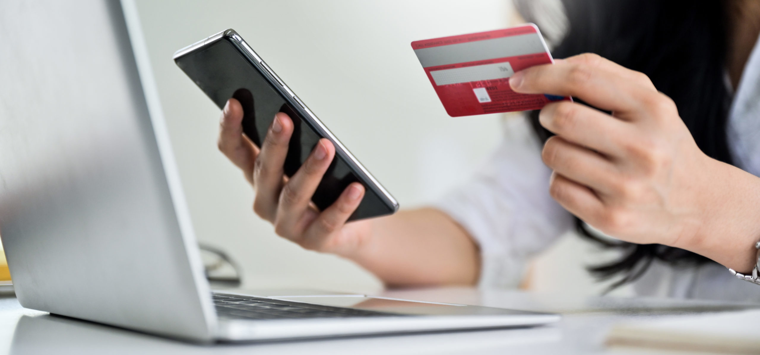 Young woman holding credit card and smartphone with laptop, Online shopping concept, Credit card payment.