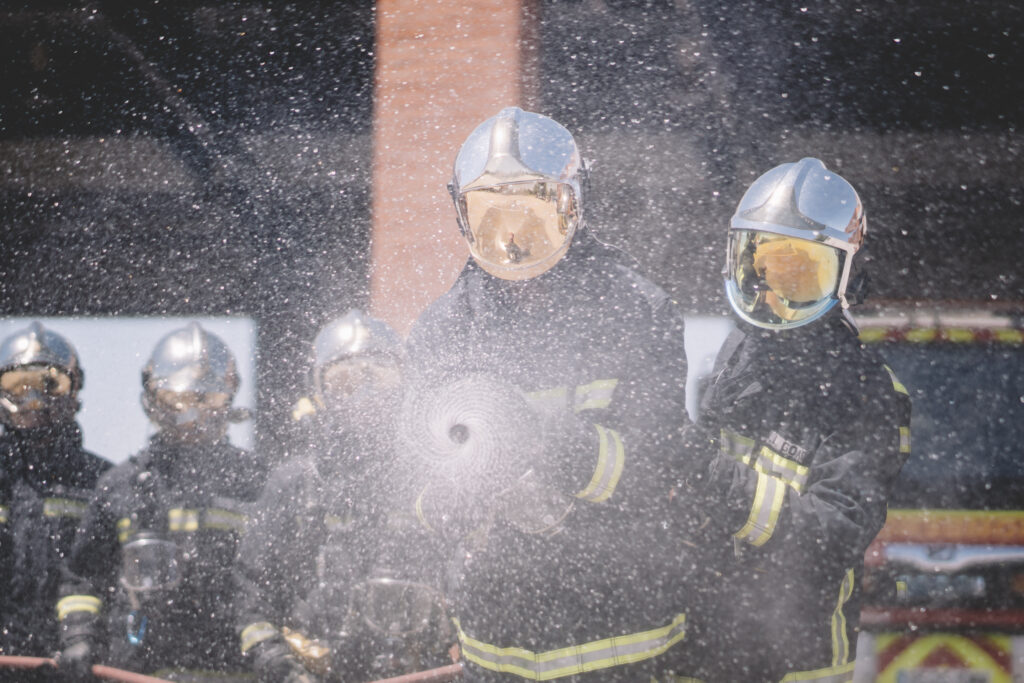 Working firemen throw water with hose